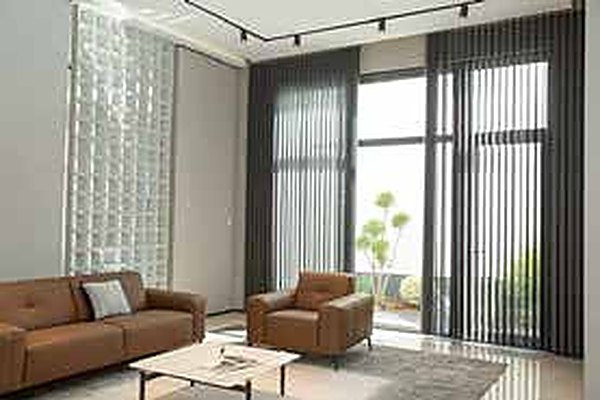 Jaluzele verticale tip perdea cu lamele textile într-un living modern