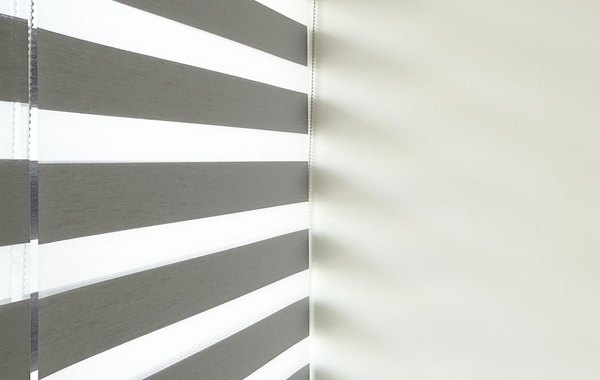 Roletă Day & Night zebra cu dungi transparente și opace alternând pe fereastra unui living